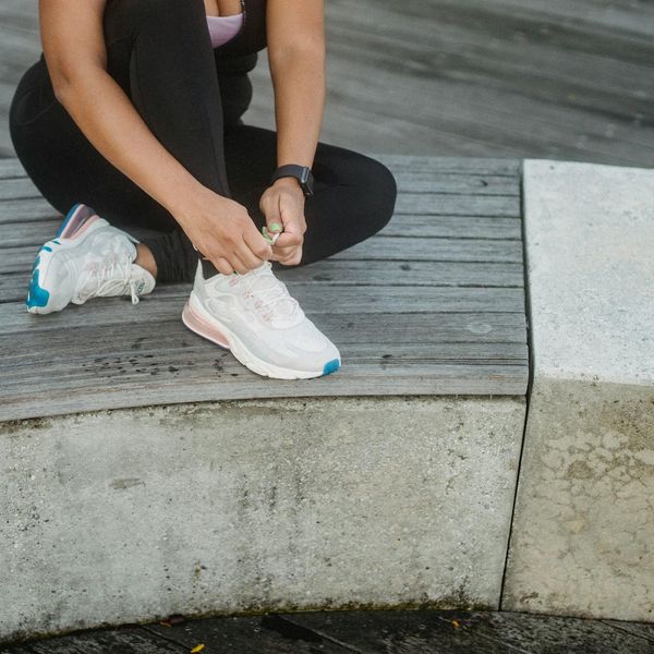 A collection of items for exercise: water bottle, towel, and comfortable shoes.